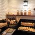Luminor Hotel Jemursari by Wh, Surabaya: buffet table with assorted pastries and bread under wall lantern