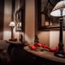 I Capricci Di Merion - Resort & Spa lounge with striped walls, sofa, lamps and festive red garland in Tuoro sul Trasimeno