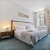 Heritage Hotel Antique Split guest room with bed, sofa, and large windows in Split