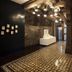 Dormero Hotel Schwäbisch Hall hallway with patterned tile floor, exposed brick walls and sculpture