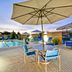 TownePlace Suites by Marriott Dallas Lewisville pool patio with umbrellas and outdoor seating in Lewisville