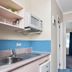 Asure Prince Motor Lodge in Taupo kitchen area with sink, microwave, blue tile backsplash and doorway