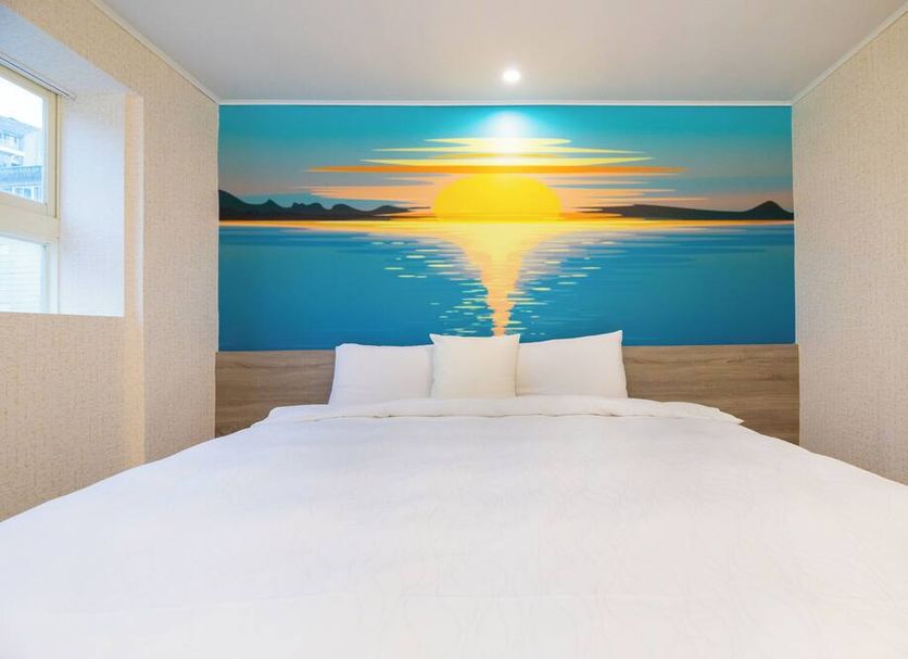 King Hot Spring Hotel in Jiaoxi Township room with bed and sunrise mural over water