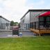 Cribs On The Hill in Picton with red patio umbrellas, grill, and outdoor seating between modern cabins