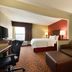 Hampton Inn Battle Creek guest room with two beds, sofa, desk, and window seating area
