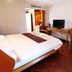 Chada Thai House Pattaya guest room with double bed, desk, TV and wicker seating