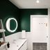 Pluvio restaurant and rooms in Ucluelet bathroom with glass shower, vanity, and dark green accent wall