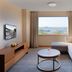 Hyatt Regency Galleria Residence Dubai room with city and water view, sofa, TV and round coffee table