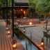 Lion Sands River Lodge in Sabie Park with lantern-lit deck, fire pit seating and outdoor dining