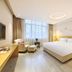 Pairui Hotel Chengdu guest room with king bed, armchair, ottoman and large window