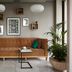 Amadi Park Hotel Amsterdam lounge with tan sofa, wall art, potted plants and side table