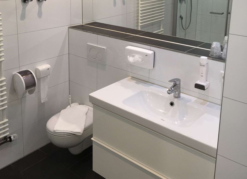 Hotel Wandinger Hof in Markt Schwaben bathroom with shower, toilet, sink and heated towel rail