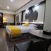 Zhehai Hotel Ningbo guest room with king bed, yellow throw, wall art and projection screen in Ningbo