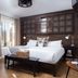 Hotel Flora and Fauna in Wimberley: cozy guest room with king bed, window, and wood-paneled headboard