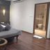 The Platinum Hotel, Hyderabad room with king bed, armchair, side table and bathroom door