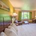 Parkwood Lodge in Fish Creek guest room with king bed, TV, desk, and window with green curtains