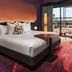 The Rally Hotel at McGregor Square in Denver guest room with king bed, floor-to-ceiling window and lounge chair