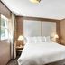 The Garden Hotel & Resort in Fort Lauderdale guest room with king bed, bedside lamps, and window view