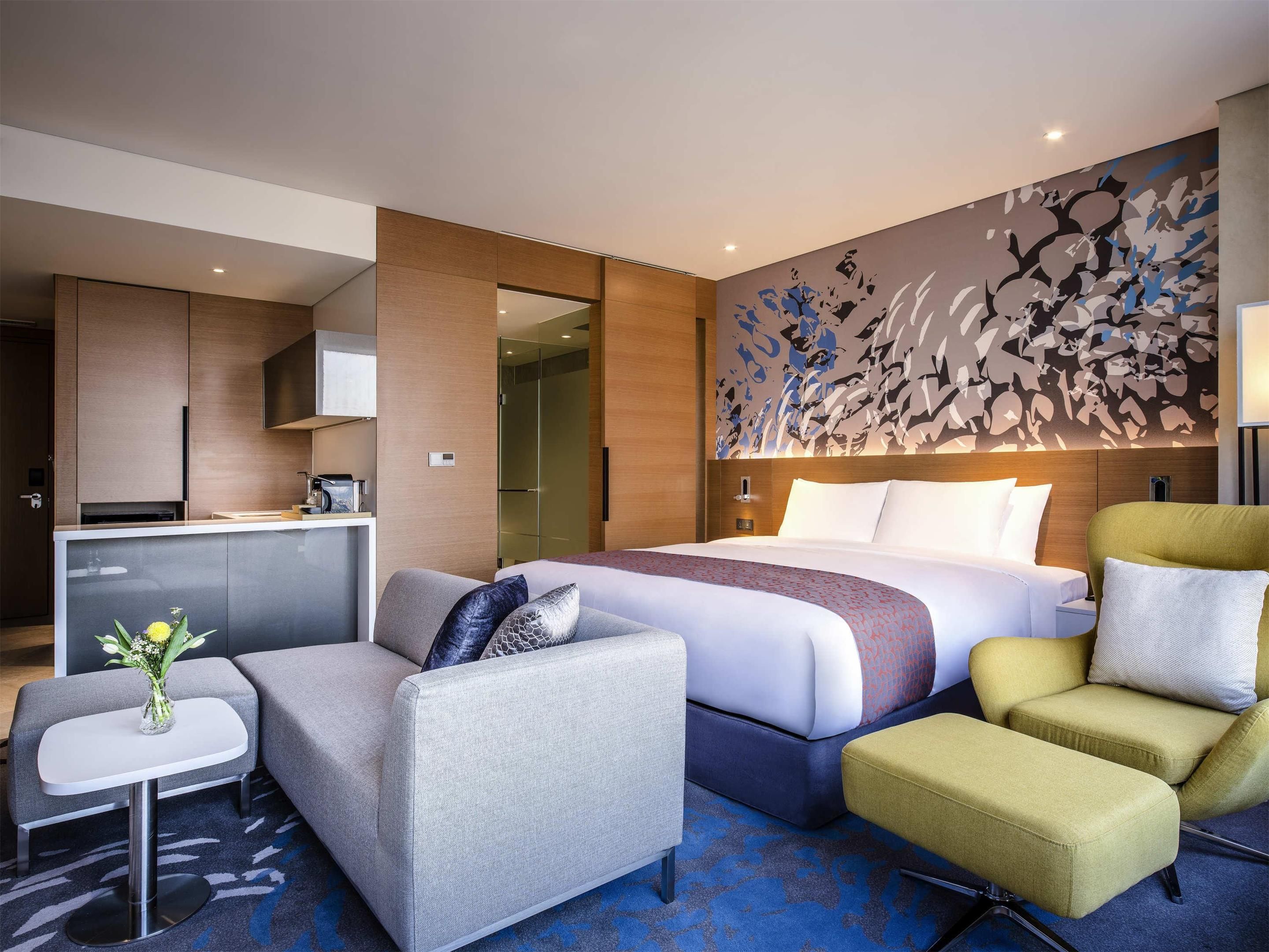 Novotel Suites Ambassador Seoul Yongsan suite with bed, seating area, and kitchenette in Seoul