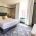 Historic Franklin Hotel Deadwood guest room with king bed, patterned carpet, and tall windows