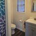 Pacific City Inn bathroom with shower curtain, toilet, vanity sink and wall mirror in Pacific City