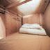 bnbplus Niigata Book Inn in Niigata: compact wooden capsule-style room with a bed