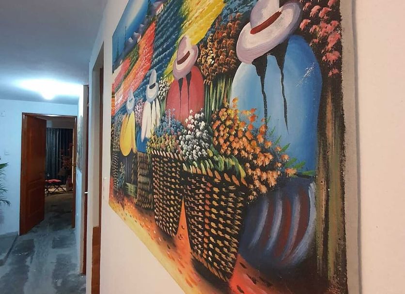 Mundo Albergue Aeropuerto in Lima hallway with colorful wall art and open doorway