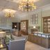 De Vere Latimer Estate in Chesham lobby with chandeliers, wood reception desk, display cabinets and fireplace