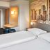 B&B Hotel Frankfurt-West room with twin beds, small desk and city skyline wall art in Frankfurt am Main
