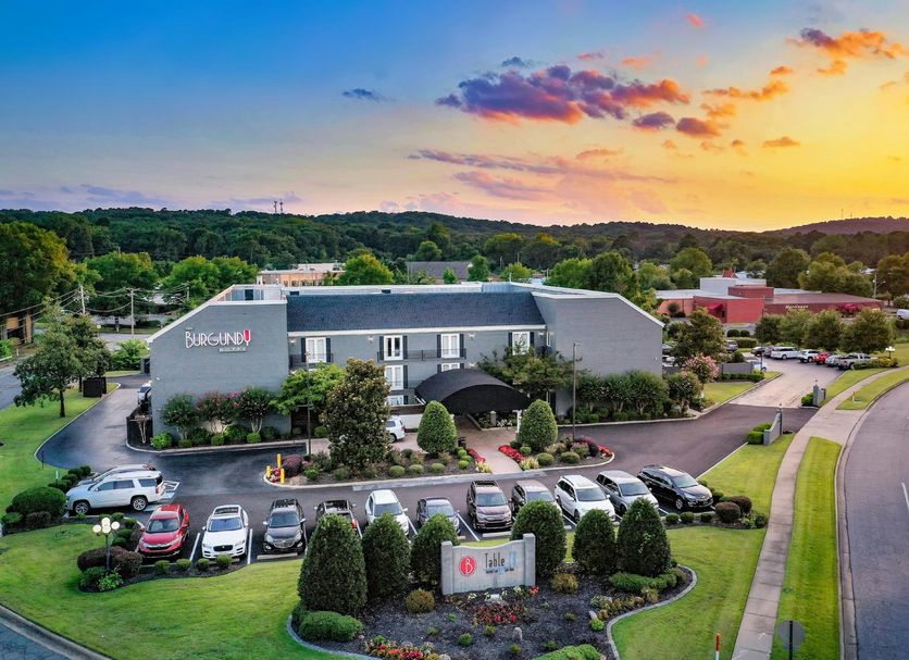 The Burgundy Hotel, Little Rock exterior at sunset with parking lot and landscaped grounds