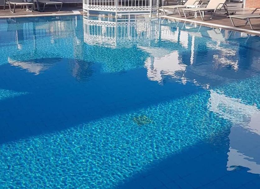 Zouboulia Apartments in Kardamena with a blue outdoor pool and lounge chairs