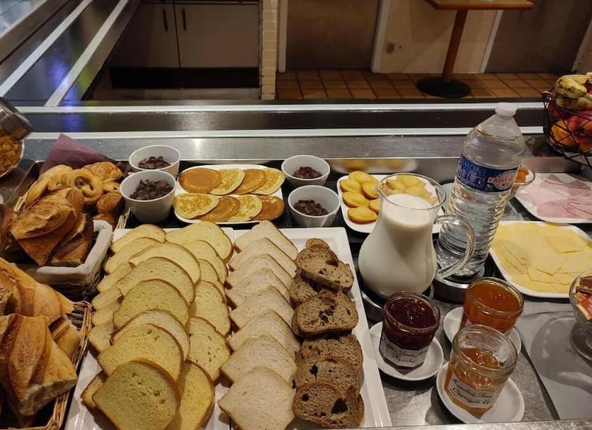 Hôtel Inn Design & Restaurant Bourges breakfast buffet with sliced bread, pastries, fruit, yogurt and drinks