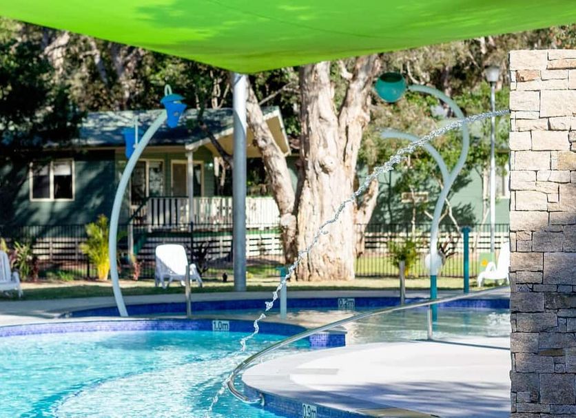 Nrma Budgewoi Holiday Park pool with shade sail and lounge chairs in Budgewoi