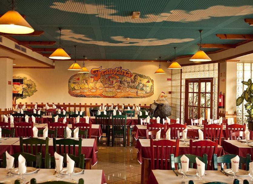 Hospedaria Frangaria in Faro dining room with neatly set tables and colorful chairs