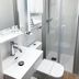 Pensión Régil in San Sebastian bathroom with shower, sink, toilet, and wall-mounted towel warmer