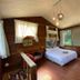 Mhuwe hotspring room in Ren-ai Township with wood walls, bed, large windows and forest view