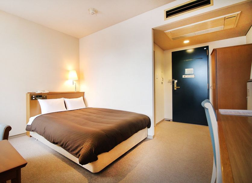 Hotel Sports Palko in Gifu: simple guest room with double bed, desk, chair, and entry door