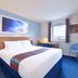 Travelodge Hull Central guest room with double bed, window view and blue chair in Hull