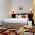 Rumah Asri Bed And Breakfast in Bandung guest room with double bed, bedside lamps, and tray table