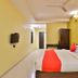 OYO 2494 Hotel Shree Plaza room in Bharuch with double bed, red accents, wall TV and ceiling fan