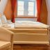 Hotel am Markt in Saarburg guest room with double bed, window, and upholstered chair