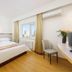 Dalian Jinbai International Hotel room in Dalian with city view, bed, chair and air conditioner