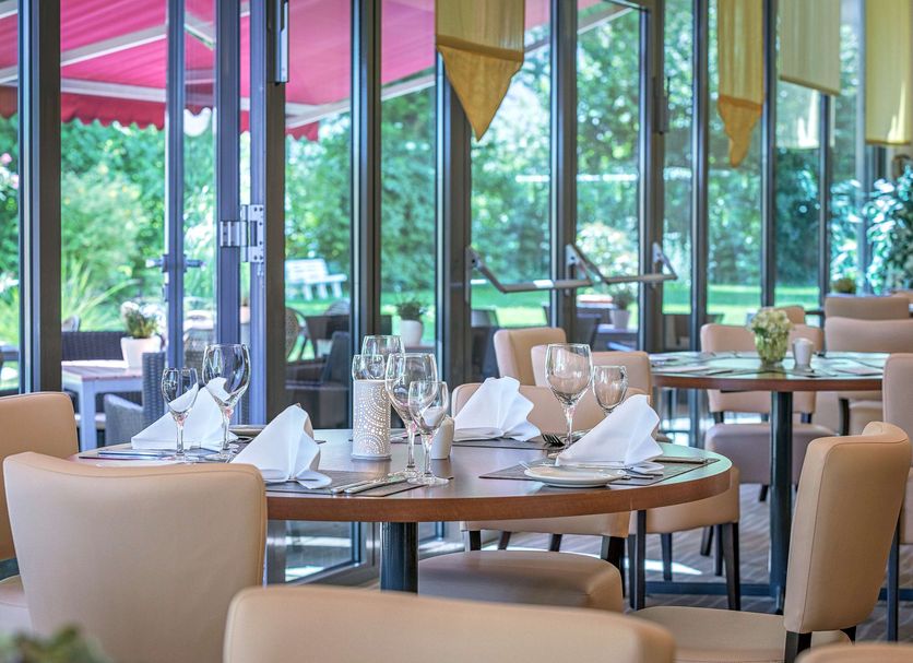 Best Western Macrander Hotel Frankfurt/Kaiserlei restaurant with glass walls and set dining tables in Offenbach am Main