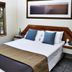 Hotel Kununurra room in Kununurra with king bed, bedside tables and window view to tropical greenery