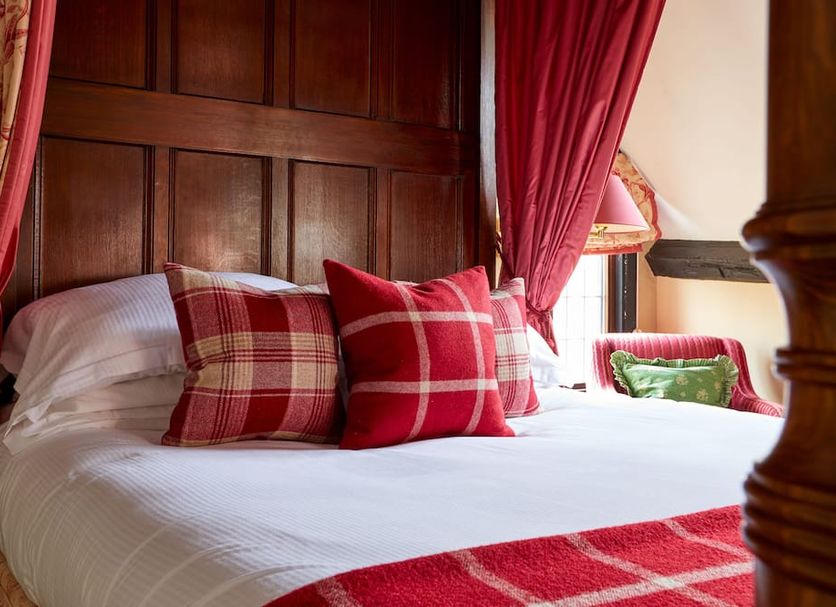Burford House Bh, Burford: cozy bed with red plaid pillows and curtains in a wood-paneled room