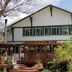 Historic Smith Hotel B&B in Glendale with a wooden porch, green-trimmed facade, and garden courtyard