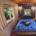 Up The Creek Backpacker's Lodge in Roberts Creek bedroom with bed and forest views from windows