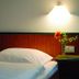 Berghotel Brockenblick room in Hildesheim with single bed, wall light and flower vase