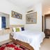 Wisma Rimadi Guest House Jakarta guest room with bed, wall art, air conditioner and wardrobe