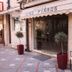 Hotel King Pyrros entrance in Ioánnina with awning, glass door, potted plants and sidewalk seating
